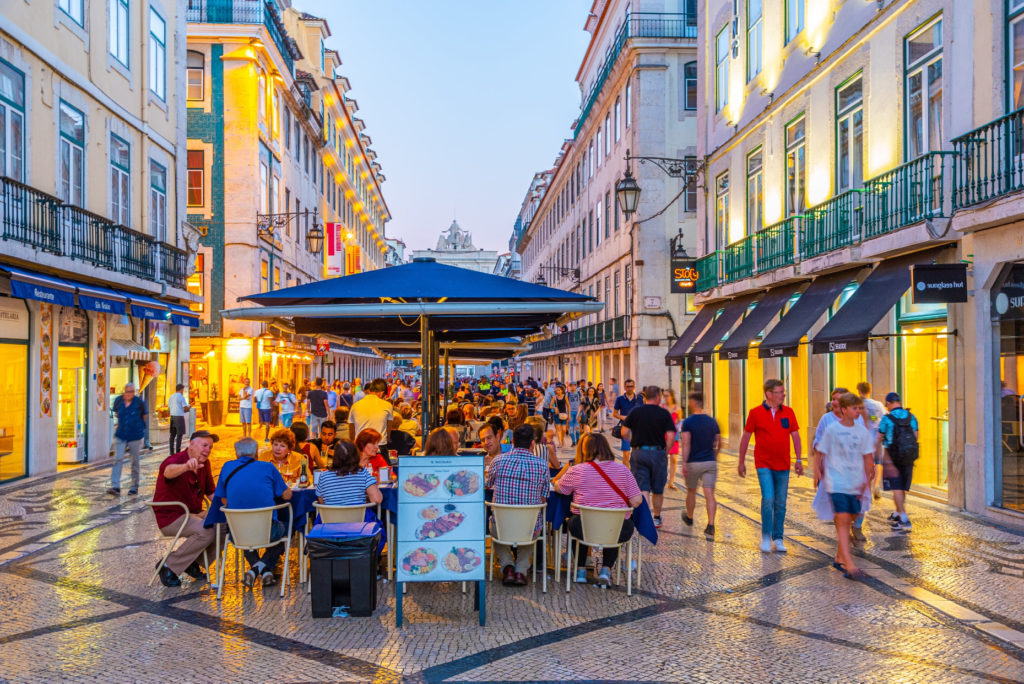 People are strolling on street leading to Praca do Comercio in Lisbon, Portugal