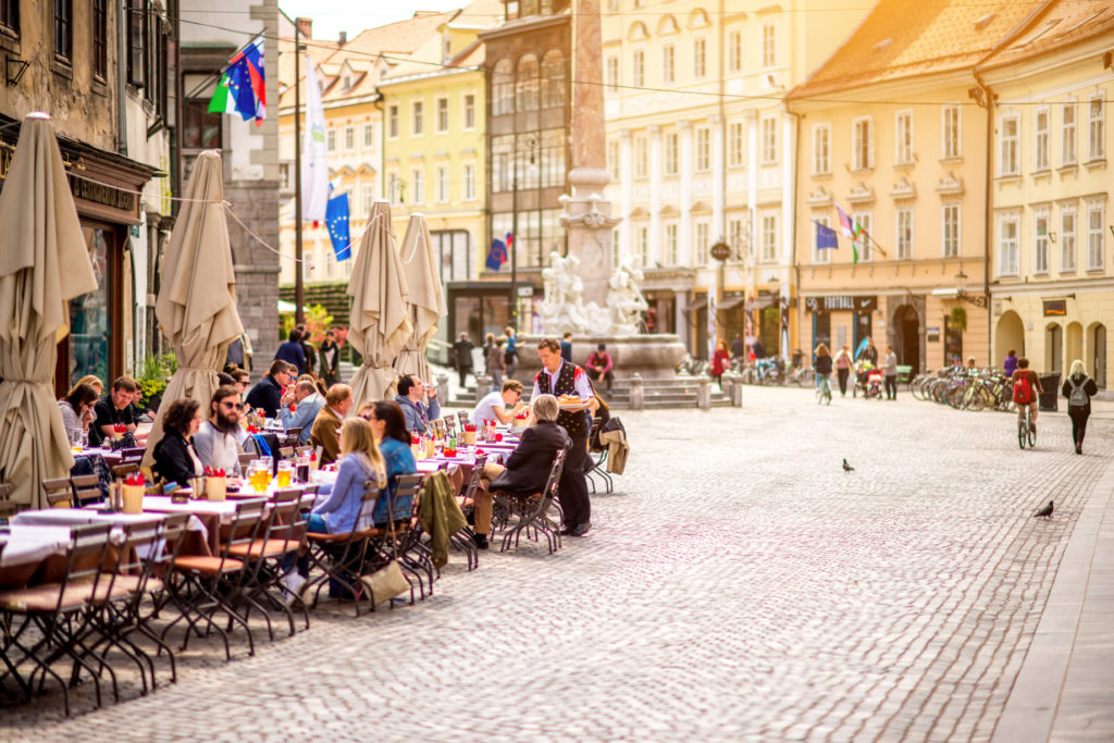 People sitting at the cafe in the old city centre near the city hall in Ljubljana. Ljubljana is the capital of Slovenia and famous european tourist destination.
