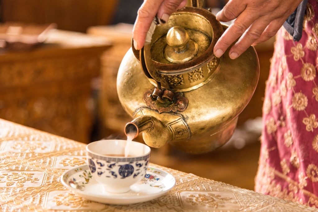 A Ladakhi lady serving salt butter tea in traditional way