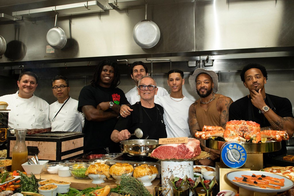 Chef Wolfgang Puck and his team pose with the Black Power Kitchen team at the 94th Annual Academy Awards Governors Ball Press Preview held at the Hollywood and Highland Center on March 24, 2022 in Hollywood, California. (Photo by VALERIE MACON / AFP) (Photo by VALERIE MACON/AFP via Getty Images)